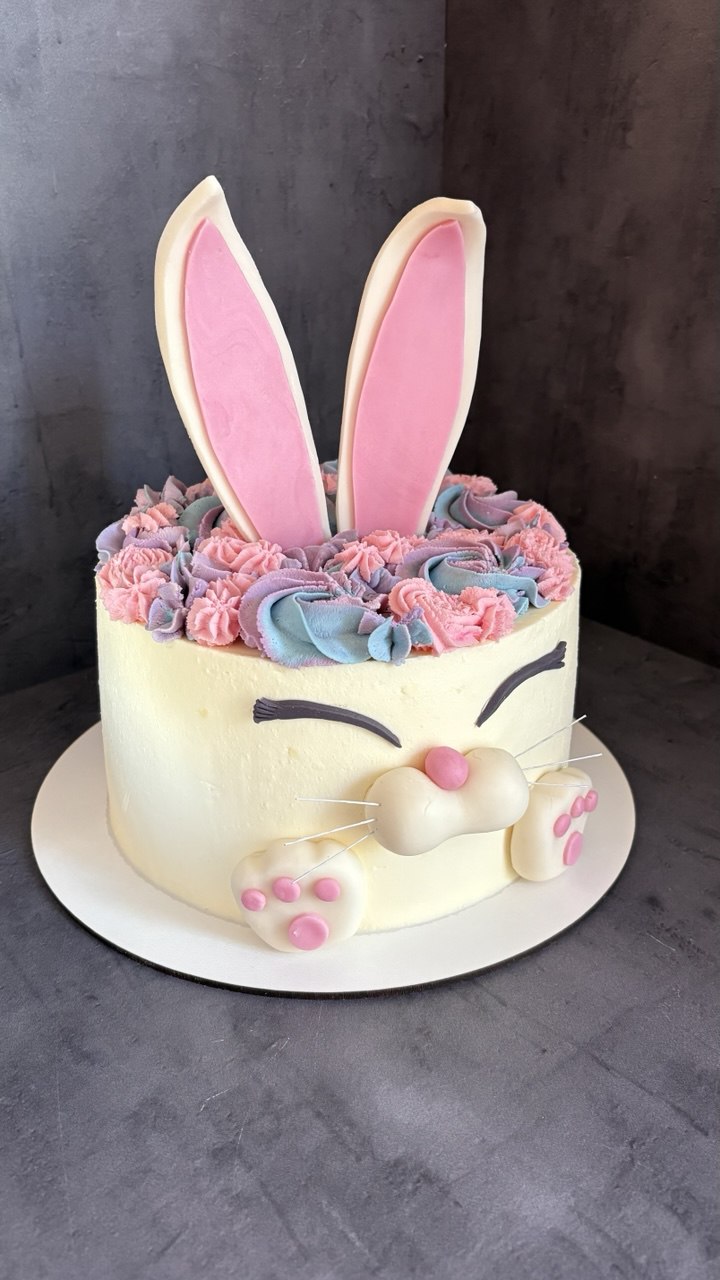 Cream bunny cake with pastel piped flowers and pink ears