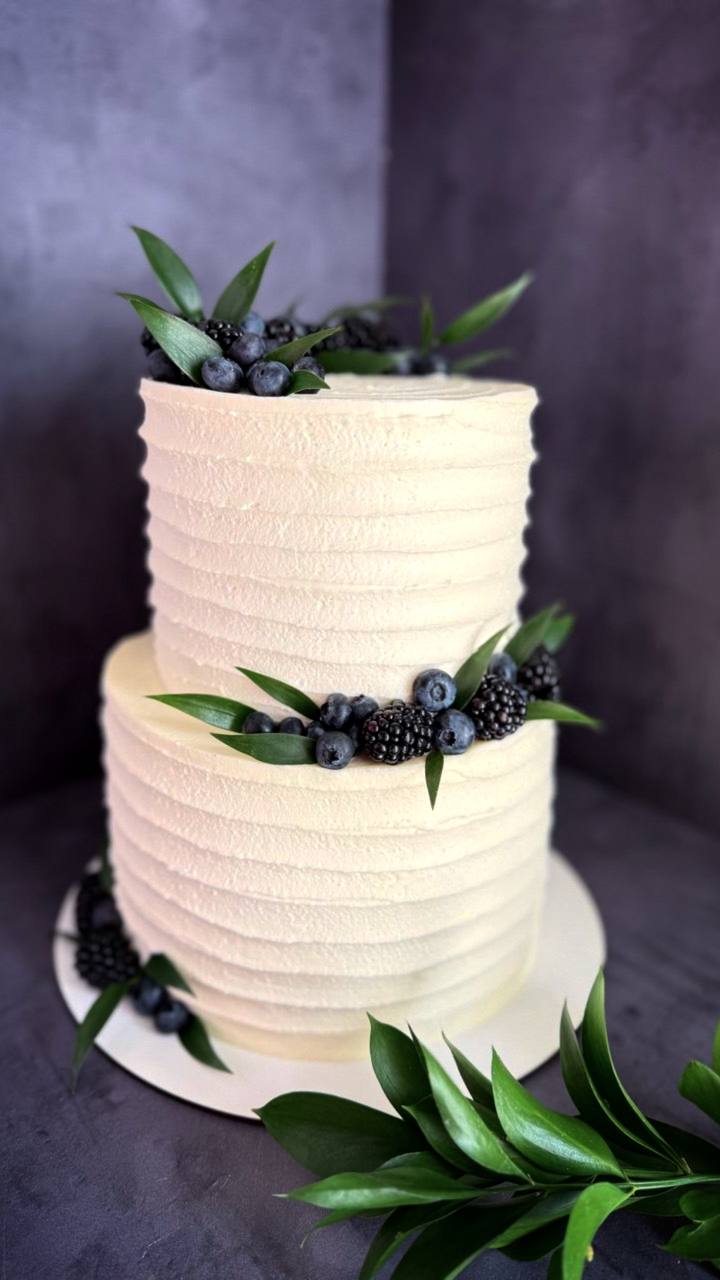 Two-tier white wedding cake with blueberries and blackberries