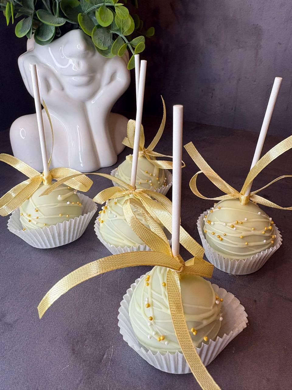White chocolate cake pops with gold ribbons