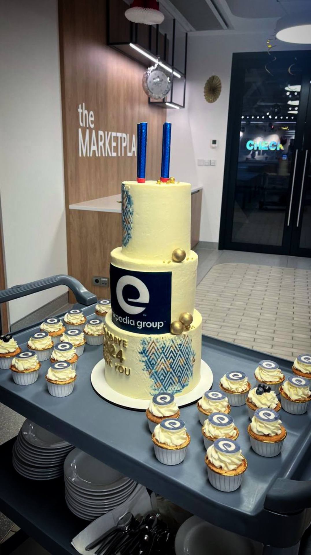 Expedia branded cake and cupcakes on catering cart