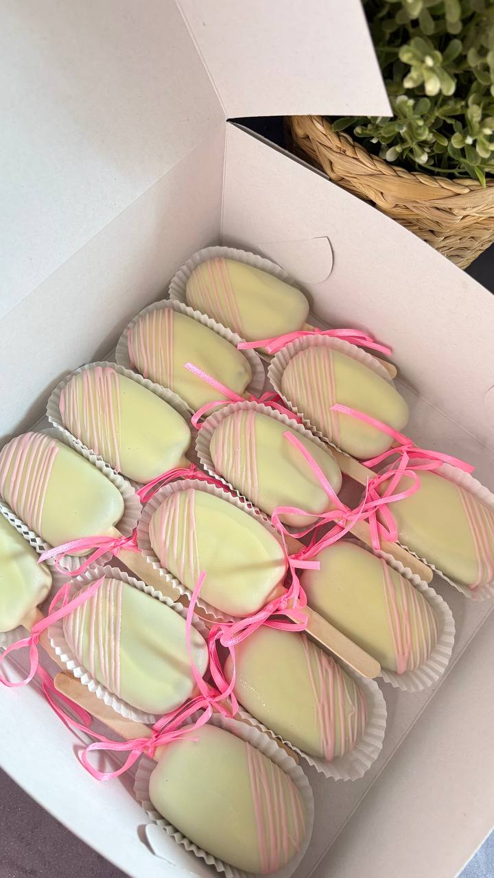 White chocolate cakesicles with pink drizzle