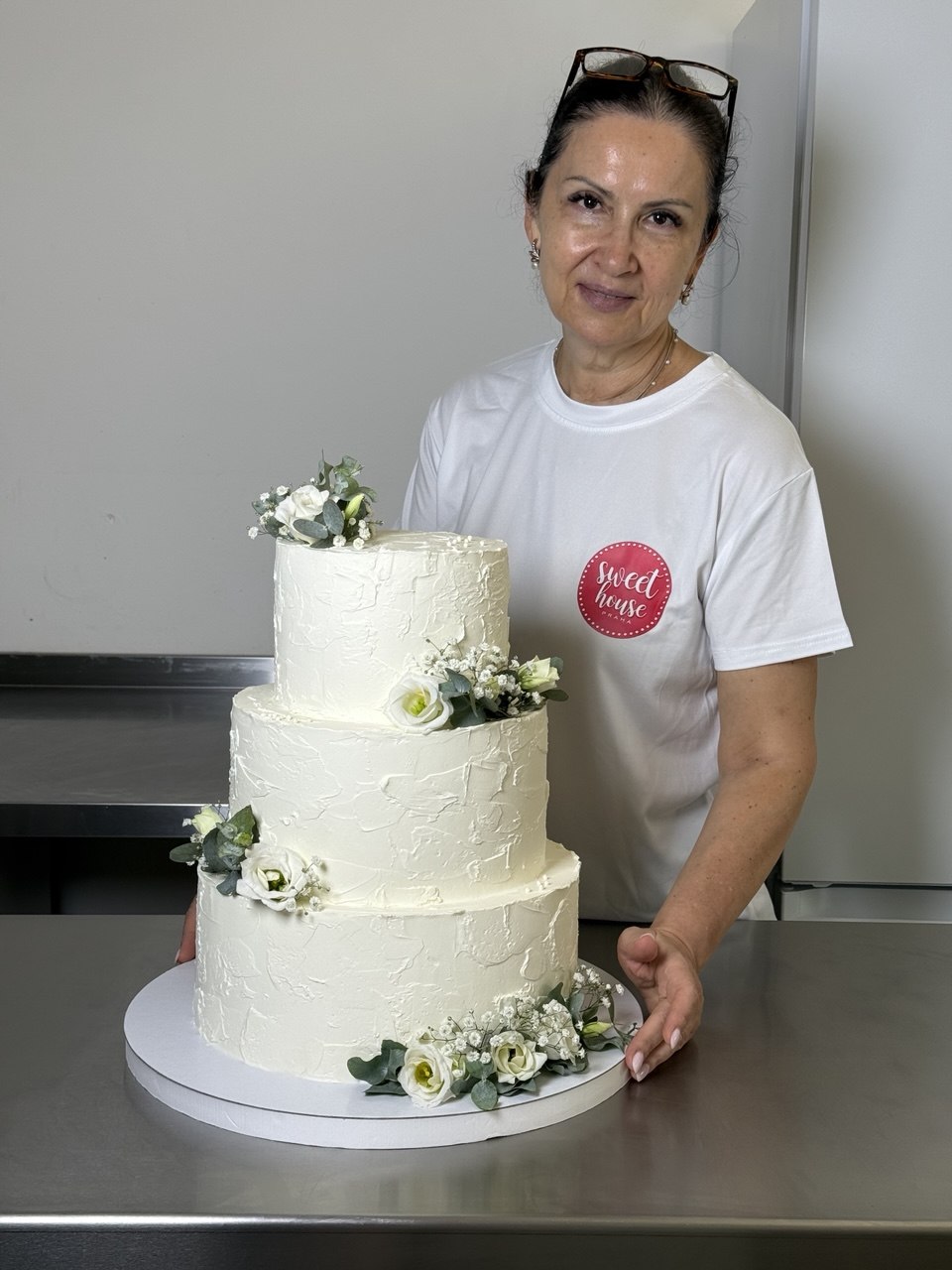 Sweet House Praha baker with three-tier wedding cake