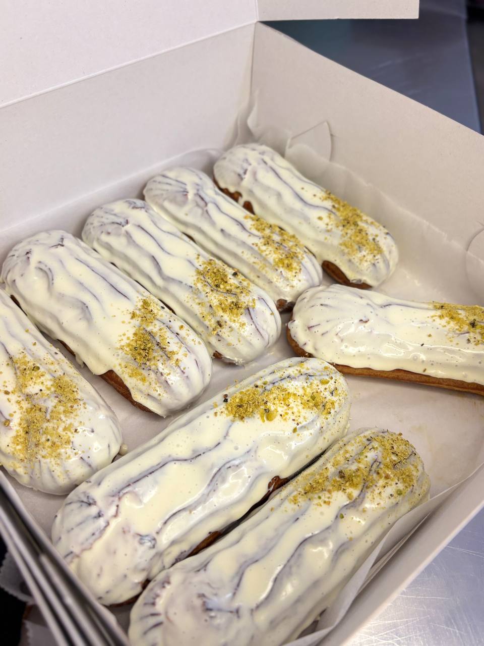 Eclairs with white glaze and crushed pistachio